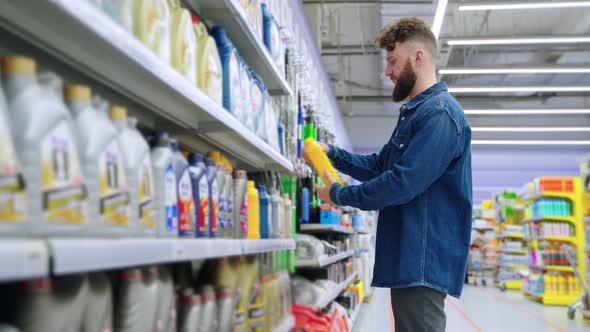 Driver is Buying Motor Oil in Store with Goods for Automobiles alt