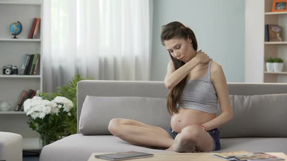 Future Mother Sitting on Sofa and Massaging Neck and Shoulders, Tensed Muscles alt