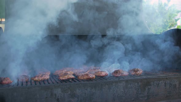 Cook Turns Meat On Grill alt