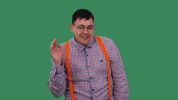 Portrait of a Smiling Man Looking at the Camera and Waving His Hand in Greeting alt