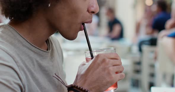 Man Drinking Cocktail at Happy Hour Aperitif in City cafe.Spritz cocktail.Medium Portrait Shot alt