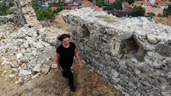 Woman Traveller Investigating Old Ruins in Ancient Castle, Discover History, Aerial Shot From Drone