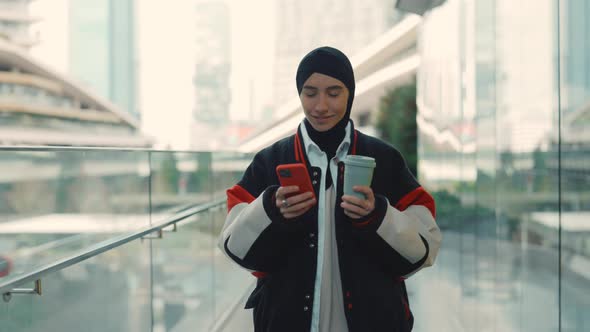 Woman in Hijab with Mobile and Coffee Walking at Mall alt