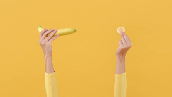 Woman hands showing banana and condom for safe sex and contraceptive concepts