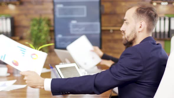 Successful Young Businessman Looking at Charts on His Tablet in the Conference Room alt