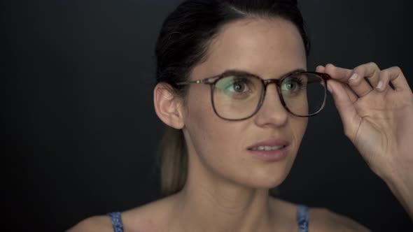 Woman looking through glasses, smiling alt