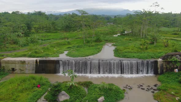 Aerial dolly view revealing Grojogan Watu Purbo Waterfall, Java, Indonesia alt