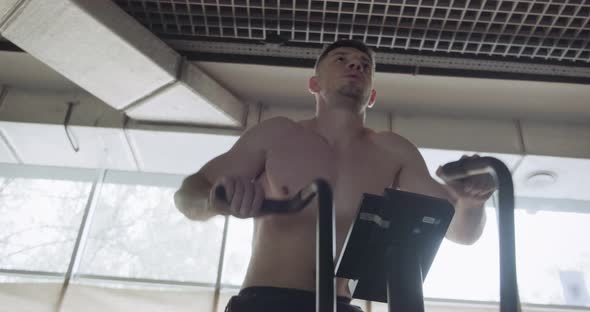 Training with Intense Cardio Bike, Exercise in Closed Gym. Men Doing Difficult Cardio Workout with alt