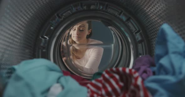Woman washing her smartphone in the washing machine