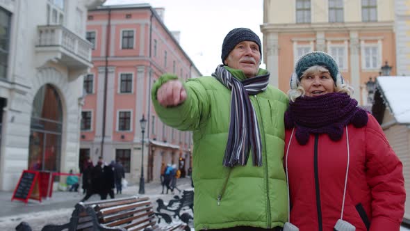 Senior Old Couple Tourists Man Woman Walking Talking Gesturing in Winter Snowy City Lviv Ukraine alt