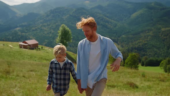 Father Son Talking Outdoors Walking Mountain Slope Closeup alt