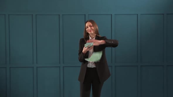Young Happy Businesswoman Dancing and Throwing Money. Slow Motion. Successful Business or Winning alt