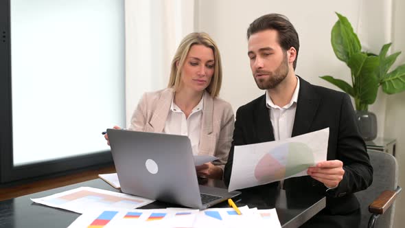 Male Businessman is Talking with His Female Colleague in the Office While Holding Documents