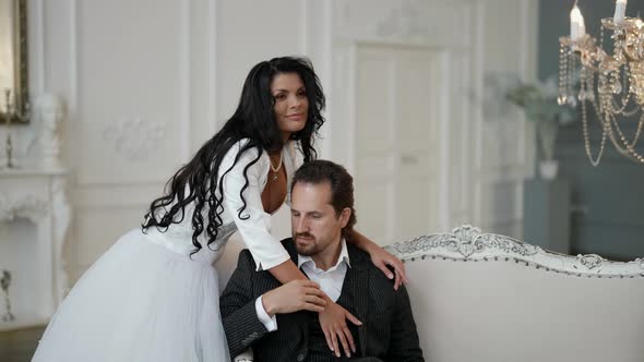 Happy Lovers in Wedding Day Smiling Bride in White Dress is Hugging Her Husband alt