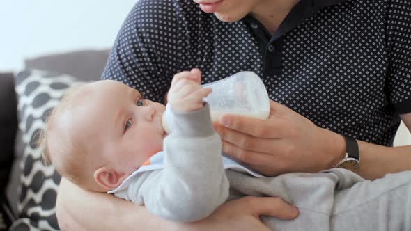 Father Feeding Baby With Milk Bottle
