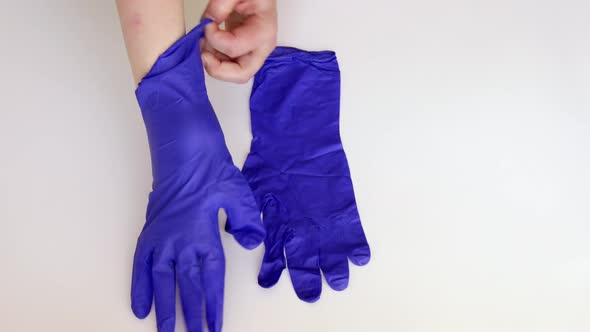 Doctor putting on blue medical latex gloves