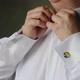 Close-up of person dressing white shirt. Cufflink emblem with pride rainbow flag. LGBT wedding - VideoHive Item for Sale