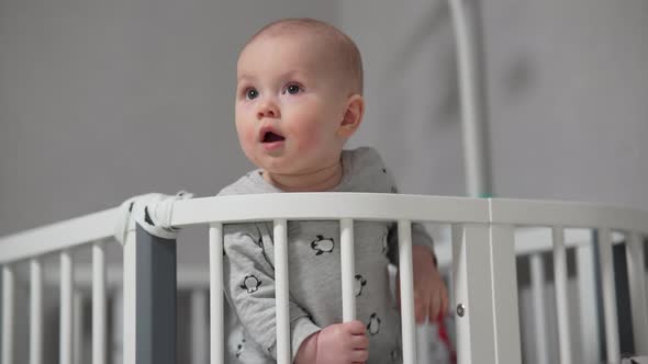 Baby Standing in a Crib at Home