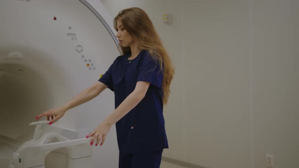 The Nurse Comes to the MRI Machine and Adjusts It Before the Work Shift at the Clinic alt
