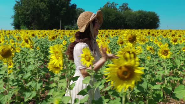 cheerful woman walking and enjoying with sunflower field