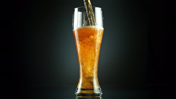 Super Slow Motion Shot of Pouring Fresh Beer Into Glass on Black Background at 1000Fps alt