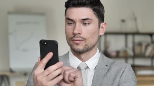 Businessman Excited for Results on Smartphone alt