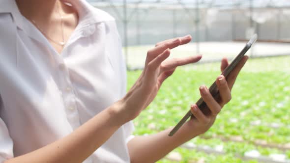 woman farmer holding tablet check order purchasing feel relax and happy looking at plant.