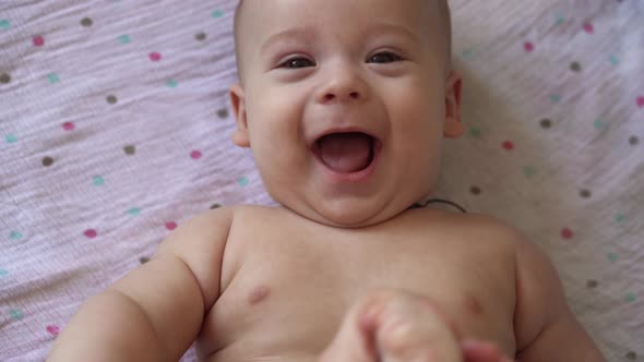 Little Naked Diaper Newborn Baby is Funny Smiling Lying at Back