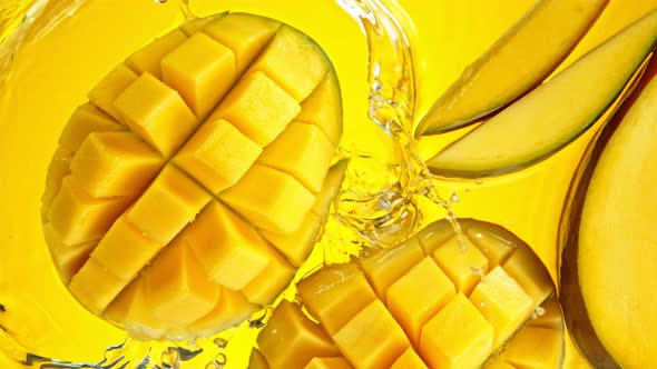 Super Slow Motion Shot of Mango Falling and Splashing Into Water on Yellow Background at 1000Fps. alt