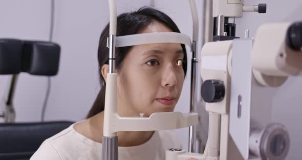 Woman do eye test at clinic alt