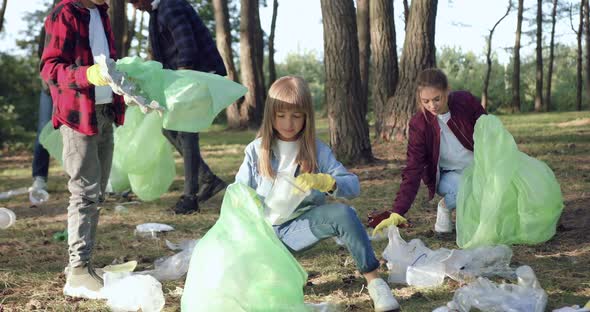 Children and Multiracial Adults-Members of Nature Lovers Charity which Cleaning Park alt