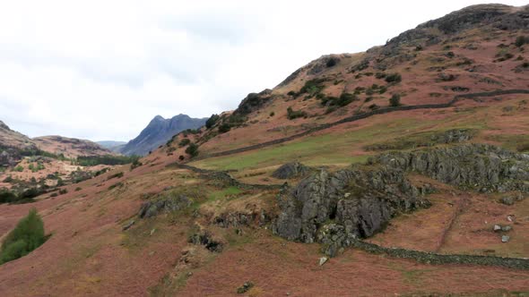 Aerial View Over Hills Towards Mountains