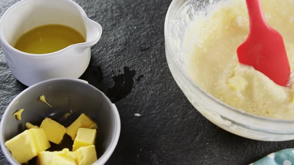 Woman adding butter cubes to batter in bowl 4k alt