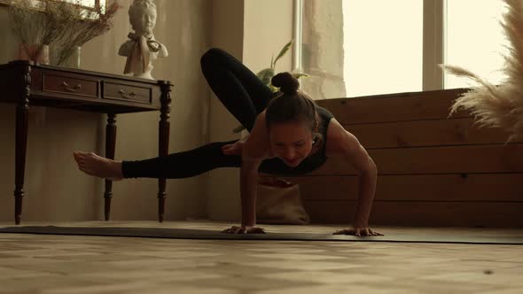 Woman Athlete Performs Complex Element of Yoga at Home