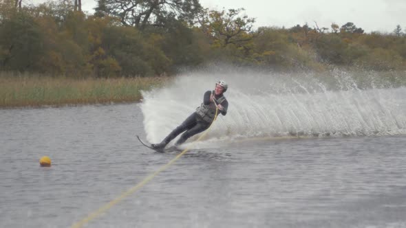Slalom slow motion water ski cut around buoy alt