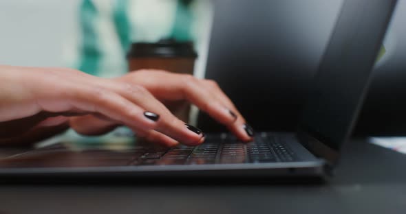 Closeup Shot of Woman's Hand Typing on Laptop Keyboard While Sitting in Office alt