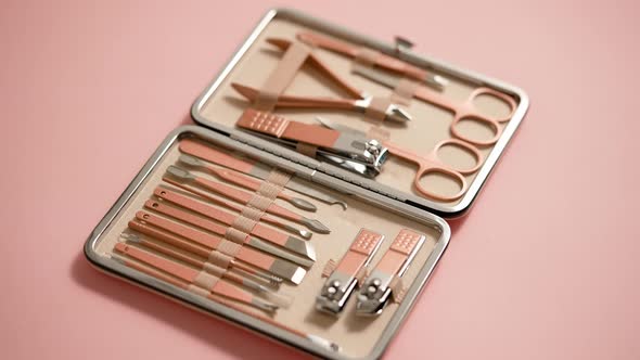Pastel Cosmetic Set for Nail Care in a Case Placed on a Pink Background