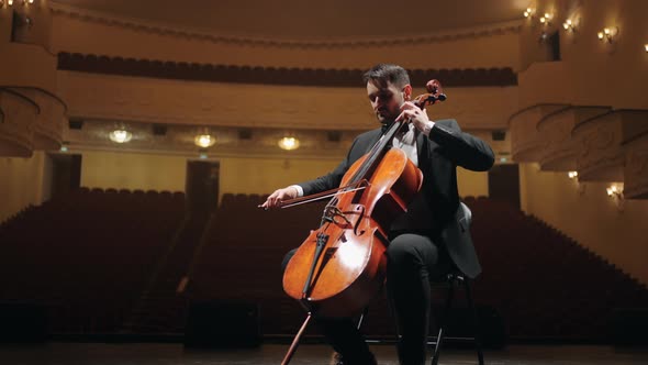 Talented Violoncellist is Rehearsing on Scene of Empty Old Opera House Portrait of Cellist in alt