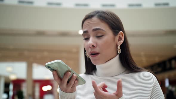 The Girl Holds a Mobile Phone in Her Hands and Speaks on Speakerphone alt