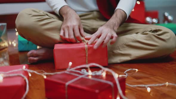 Attractive Asian man making a gift box in the living room at home.