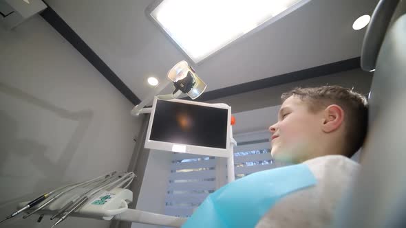The child is afraid of the dentist, little boy visiting the dentist and looking scared alt