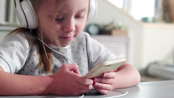 Cute Little Girl Listening to Music on Smartphone