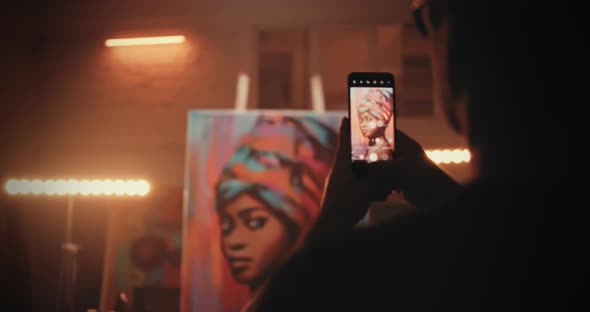 Unrecognizable Artisan Taking Picture Portrait Behind Workbench alt