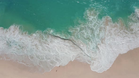 Aerial View of Blue Ocean Waves Crashing at White Sand Beach