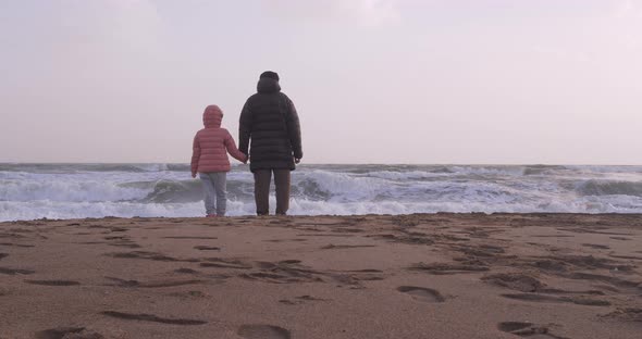 Young Girl Playing By the Sea with Her Grandfather