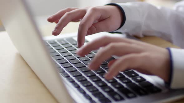 Unrecognizable Schoolchild Typing on Laptop alt