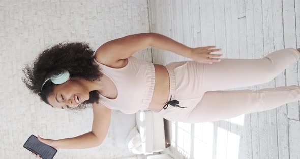 A Happy Mixedrace Woman Wearing Headphones Enjoys Moving alt