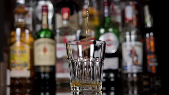 Closeup of a Bartender Pouring Whiskey Into a Glass in a Bar alt
