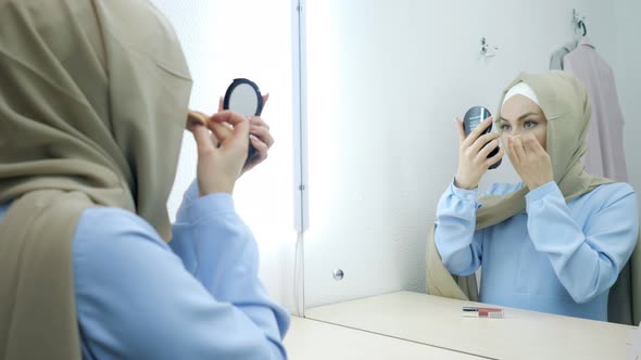 Muslim Young Attractive Woman in Beige Hijab and Traditional Blue Dress Making Makeup alt