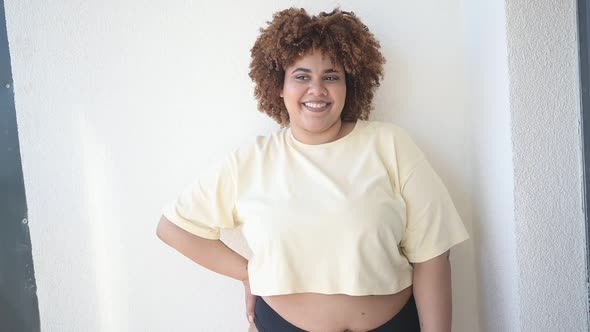 Beautiful Happy Curvy Plus Size African Black Woman Afro Hair Posing in Beige Tshirt and Black